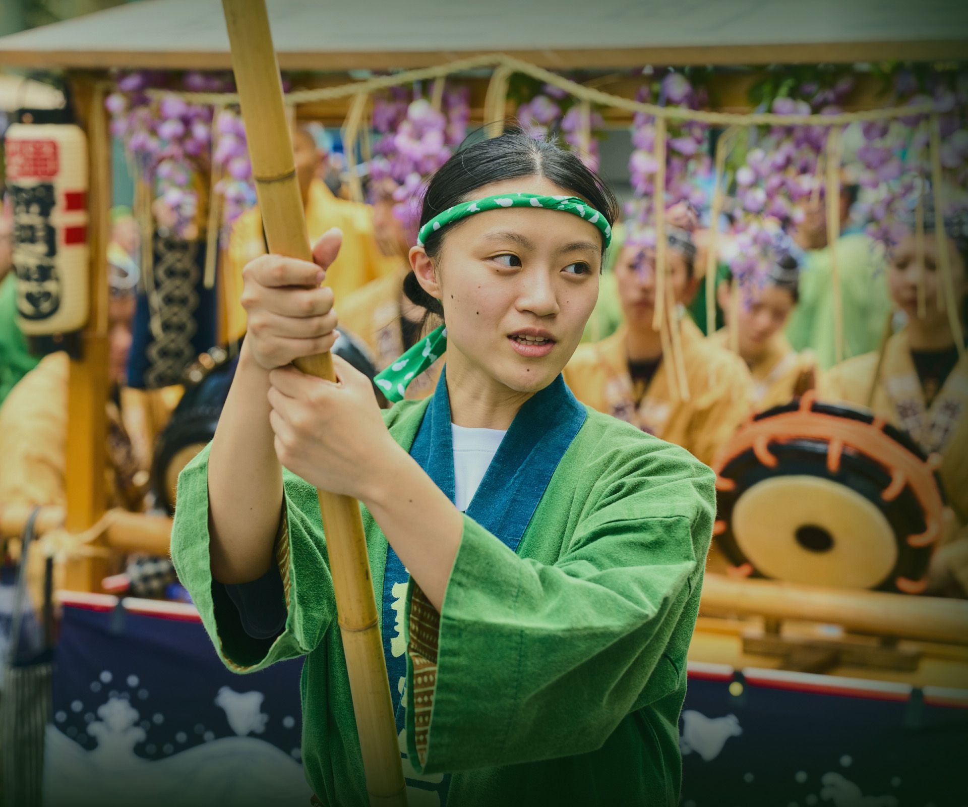 緑の法被を着て祭りに参加する女性