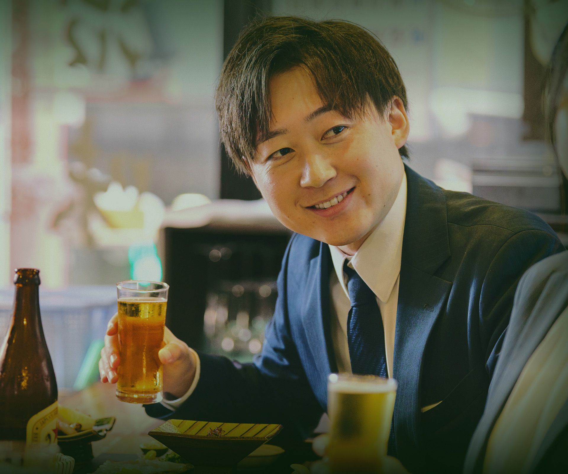 飲食店でグラスを手に笑顔を見せる男性