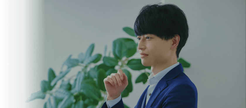 ペンを手に考えるスーツ姿の男性